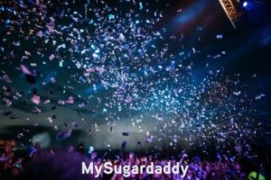 En la imagen se ve una fiesta. La gente esta con las manos arriba y disfrutando del momento. Lo que significa ser joven, disfrutar y festejar la vida. 